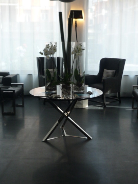 In the Hall of the Santa Margherita Palace, pair of rectangular stool AGRIFE in brass nichel plated with black quilted leather seats; in the center of the Hall a special table called SHANGAI realized in special measure, with black crystal top and base in brass nichel plated finish. 