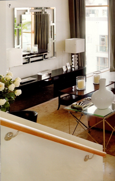 Sul tavolo PIGNA con piano in cristallo trasparente e base ottone nichelato, vuotatasche ZEBRA vera; Sul tavolo lungo coppia di BUGIE CILINDRICHE CONTEMPORANEE, in cristallo e base metallo.